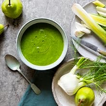 Green fennel & leek soup on a table with leeks, fennel & pears. Next to a spoon, and napkin