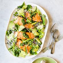 Delicious bowl of salmon & basil gremolata, on a table with fork & spoon