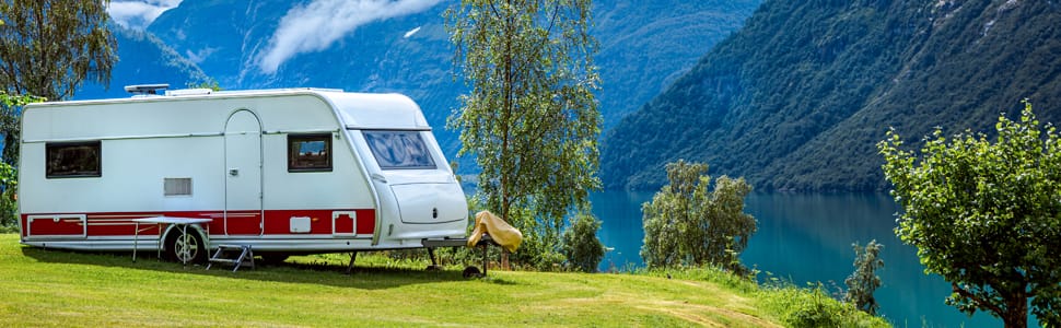 rv trailer camping by the lake in the mountains
