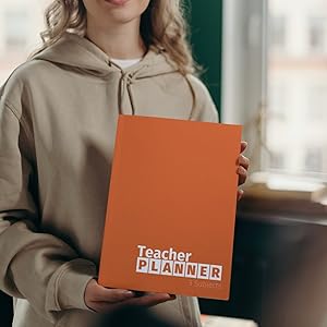 teacher holding minimalist teacher lesson plan book