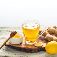 A warm cup of lemon ginger tea with honey.