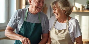 Smiling senior couple cooking together in the kitchen