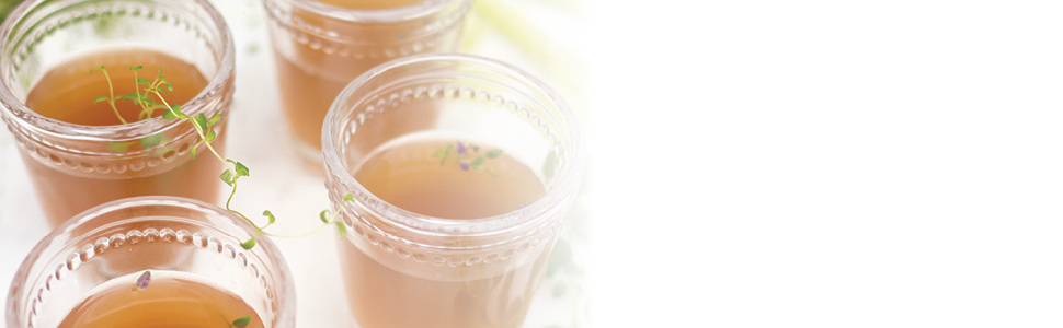 Cups of bone broth on white background